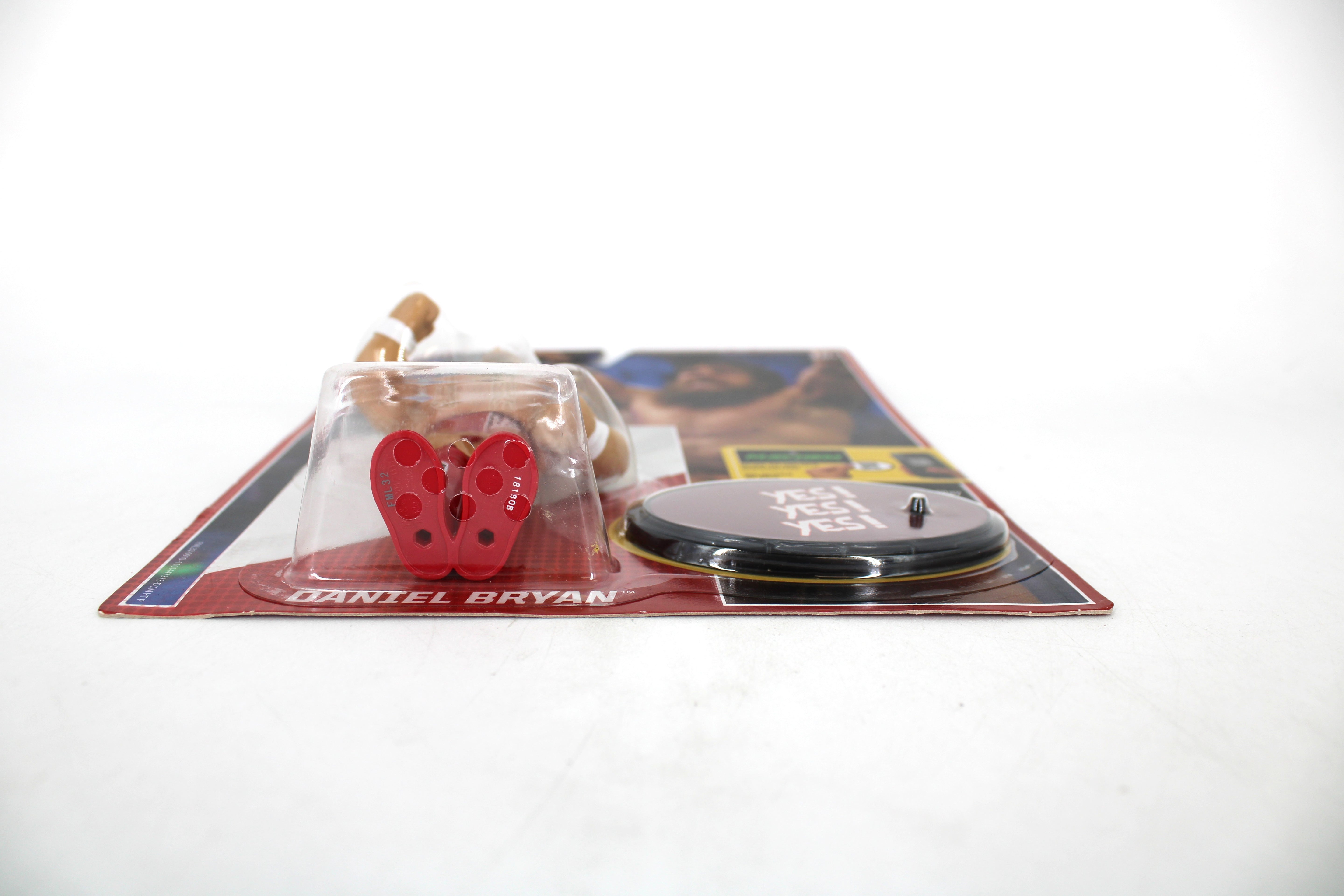 Daniel Bryan WWE Retro Series Figure — Low-Angle Side View Showing Red Accessories and Yes! Display Base on Card