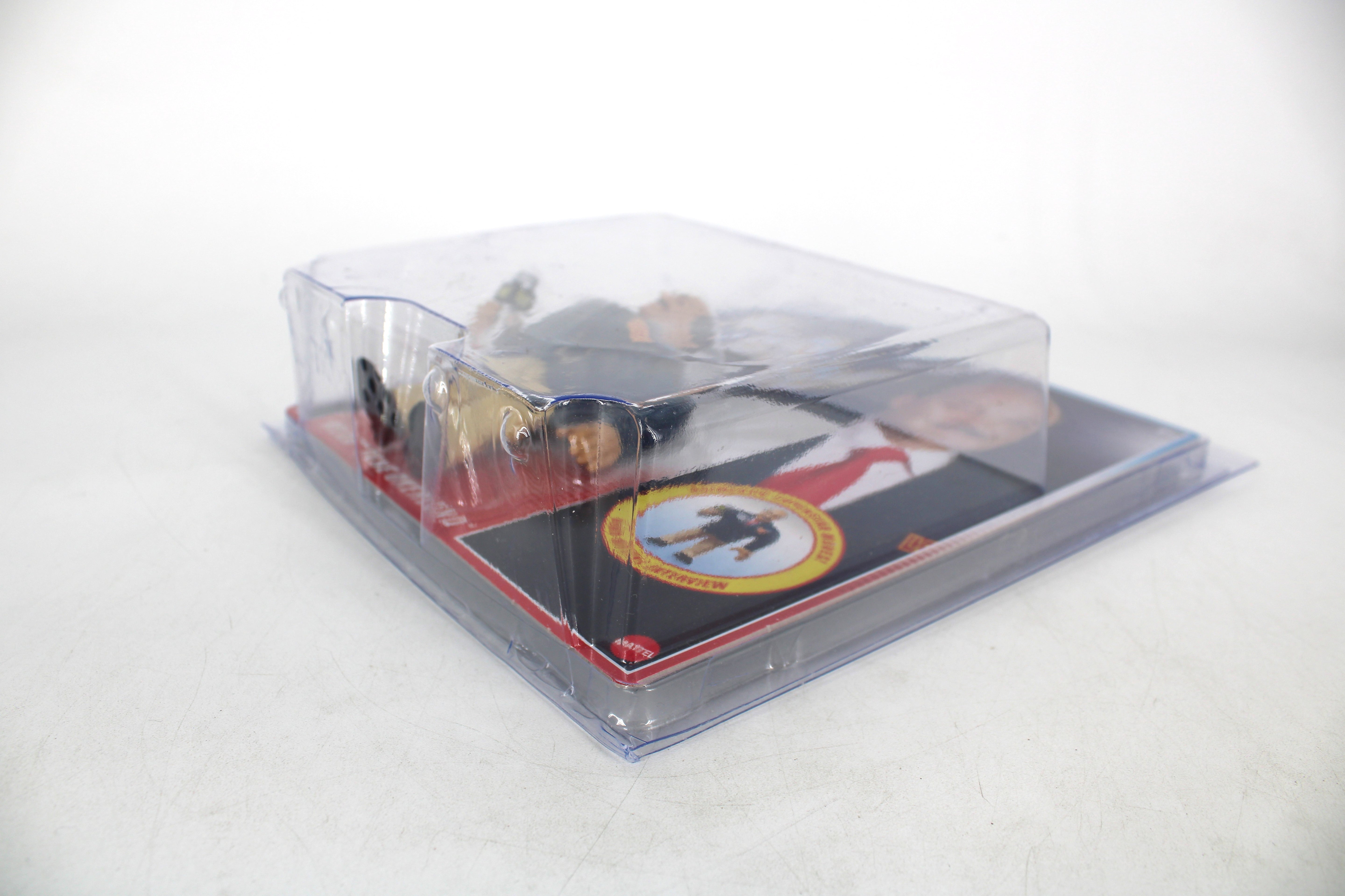 "Mean" Gene Okerlund WWE Official Retros Action Figure — Angled View in Protective Case with Card Back Detail