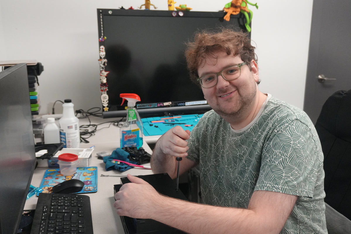 Ethan, Video Game Lead at Jay’s Toys & Games, screwdriver in hand at the console repair bench