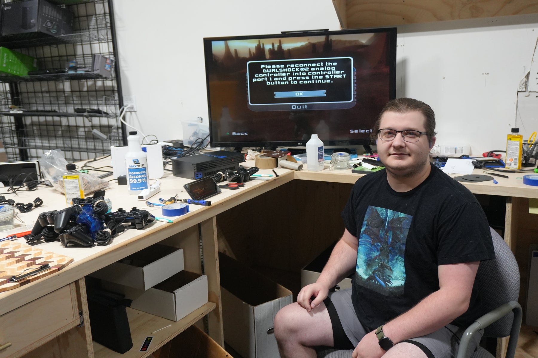 Tim, Video Game Specialist at Jay’s Toys & Games, at the console test bench with a PlayStation 2 running